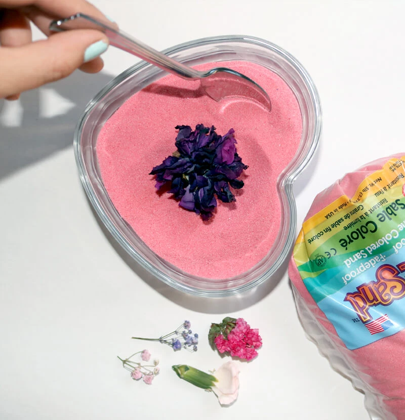 Create a beautiful dried flower and colored sand arrangement with flowers dried in the microwave.